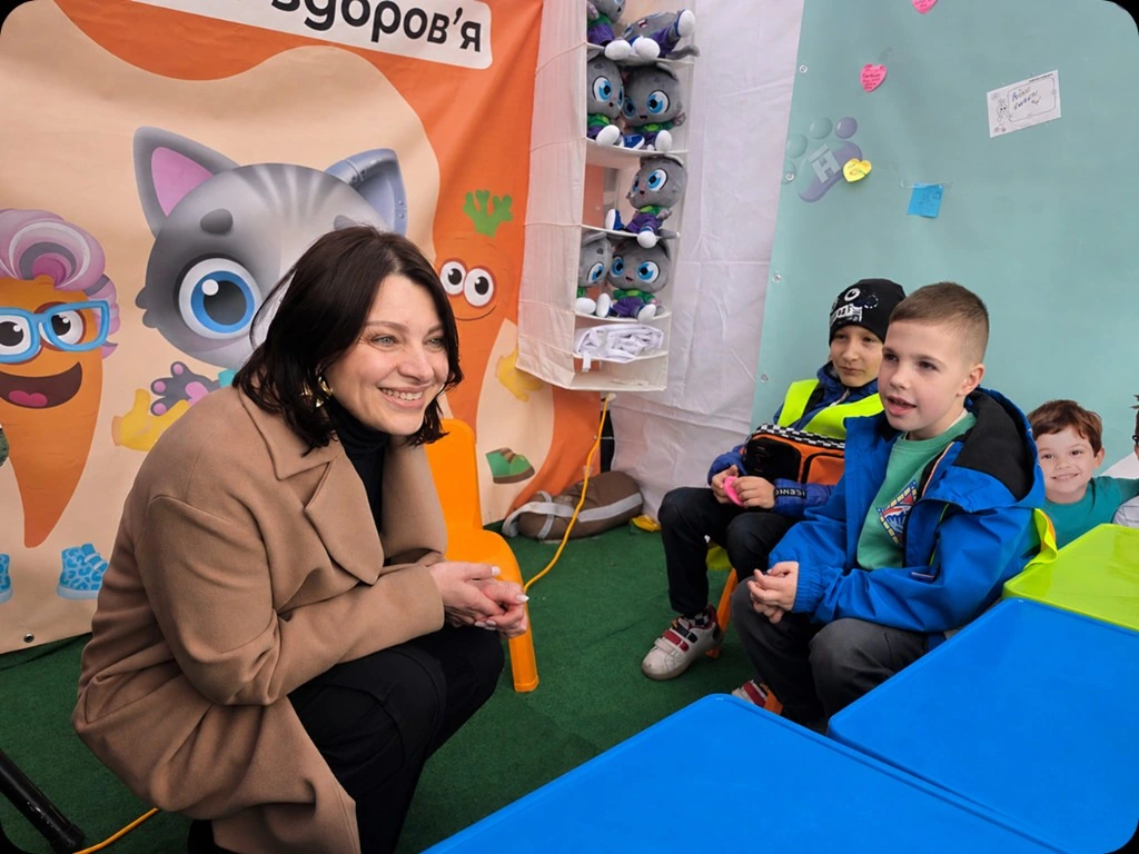 Учителька спілкується з хлопцями біля банера